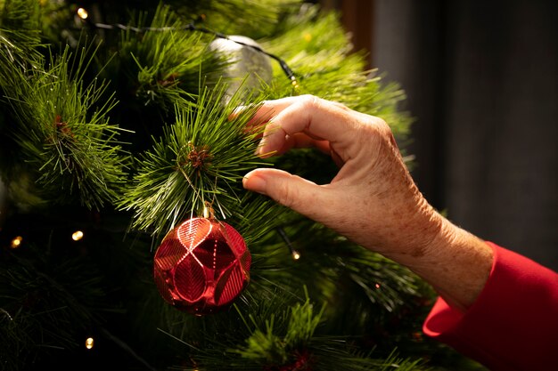 Mão de close-up, montagem de árvore de Natal