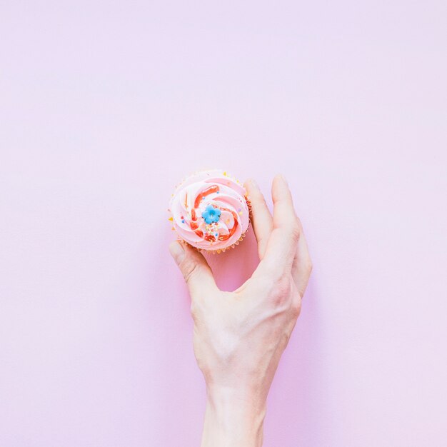 Mão de colheita com bolinho de aniversário