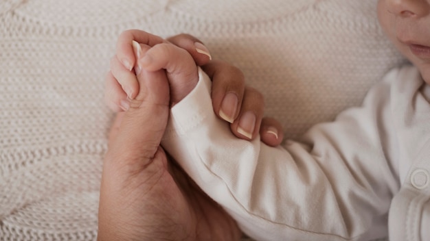 Mão de mãe segurando bebê pequeno braço