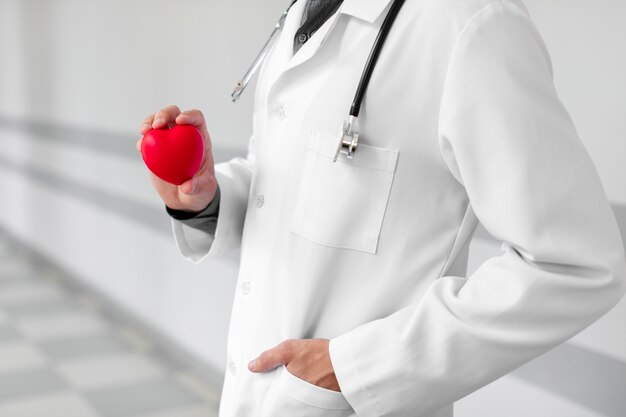 Mão de médico segurando um coração de pelúcia