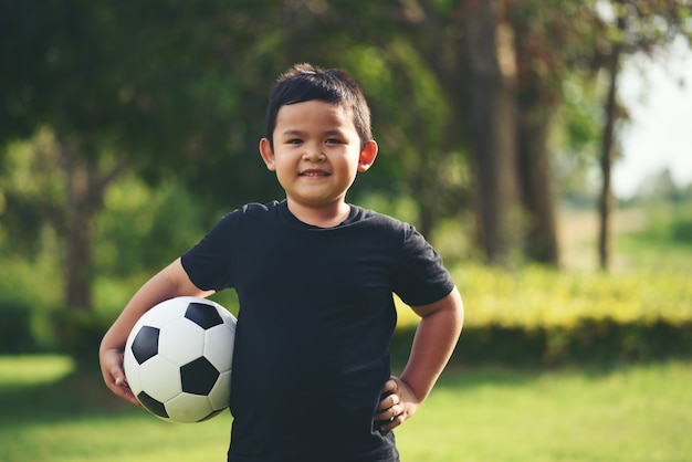 Mão de menino pequeno segurando futebol futebol
