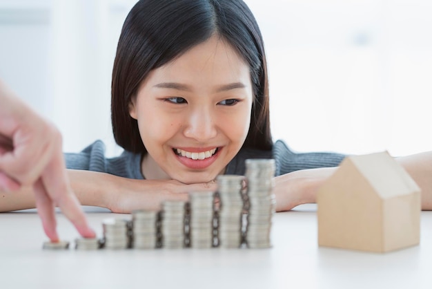 Mão de mulher asiática de felicidade com conceito de ideias de negócios financeiros de pilha de moedas
