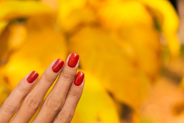 Mão de mulher com manicure laranja