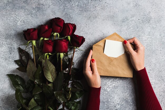 Mão de mulher de dia dos namorados segurando a carta de amor de envelope com dia das mães de cartão