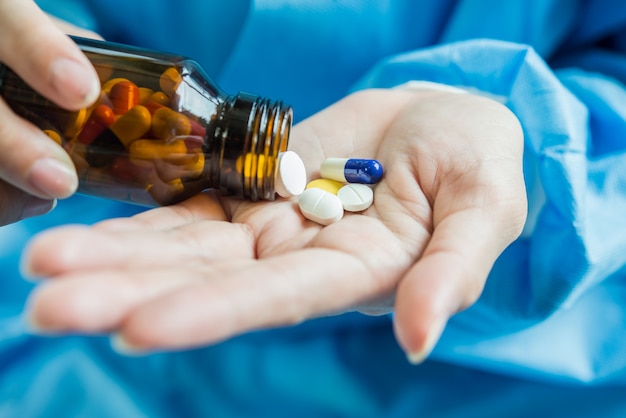 Foto grátis mão de mulher derrama as pílulas de medicamento fora da garrafa