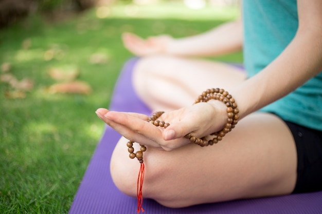 Mão de mulher meditando segurando rosários