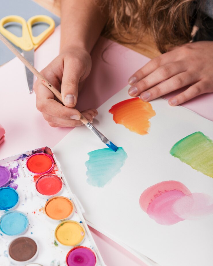Foto grátis mão de mulher pintando desenho abstrato em papel branco usando aquarela