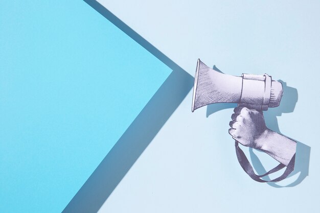 Mão de papel segurando um megafone