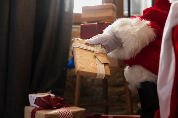 Mão de santa segurando um presente de natal