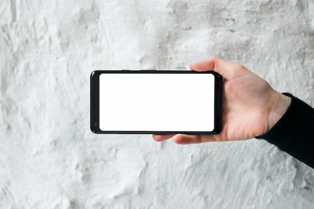 Mão, de, um, pessoa, mostrando, tela móvel telefone, contra, branca, parede concreta