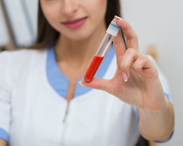 Mão de uma mulher segurando uma amostra de sangue
