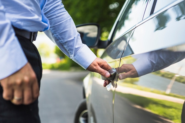 Mão do homem, abrindo a porta do carro