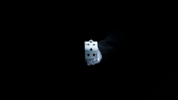 Mão do mago mostrando clube de baralho contra fundo preto