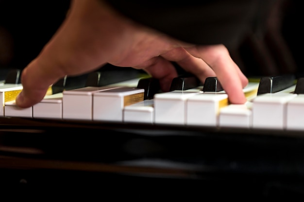 Mão em close segurando um acorde no piano