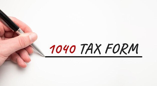 Mão escrevendo imposto 1040 com marcador vermelho. isolado no fundo branco. conceito de negócios.