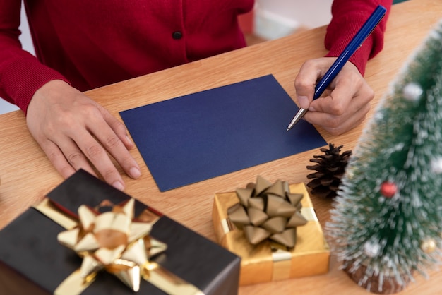 Mão escrevendo maquete de cartão de feliz Natal e feliz ano novo com decoração de Natal