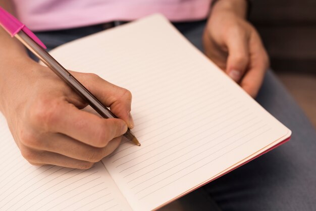 Mão escrevendo no caderno