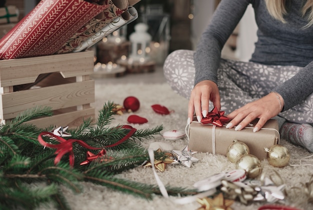 Mão humana decorando um presente de natal