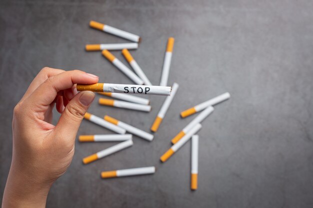 Mão humana segurando o cigarro. Mundo sem conceito do dia do tabaco.