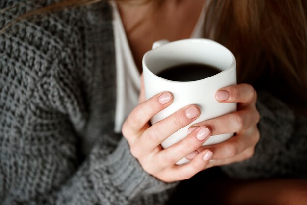 Mão humana segurando uma caneca de café