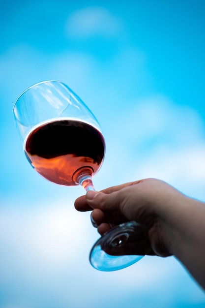 Foto grátis mão jogando um copo de vinho tinto no ar