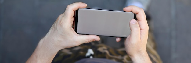 Mão masculina segura smartphone com espaço em branco