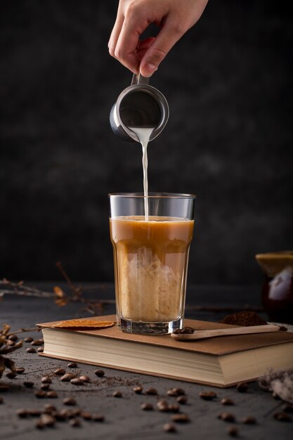 Mão plana leiga derramando leite no café