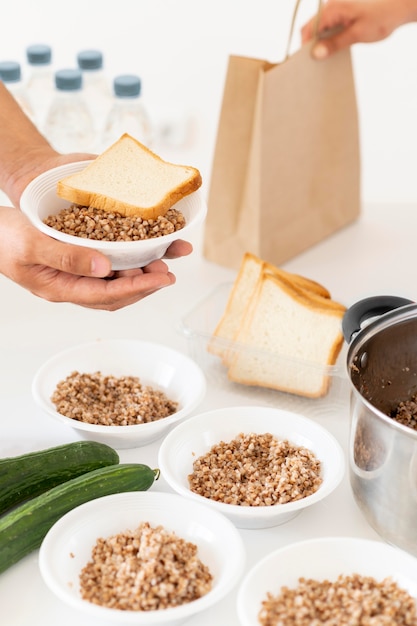 Mão preparando porções de comida para doação