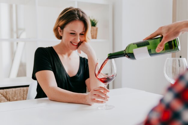 Mão que derrama vinho para namorada