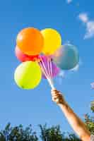 Foto grátis mão segura, cobrança, de, balões brilhantes