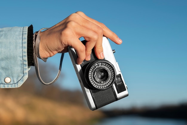 Mão segurando a câmera fotográfica