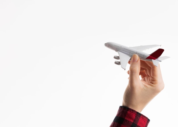 Foto grátis mão segurando a estatueta do avião com espaço de cópia