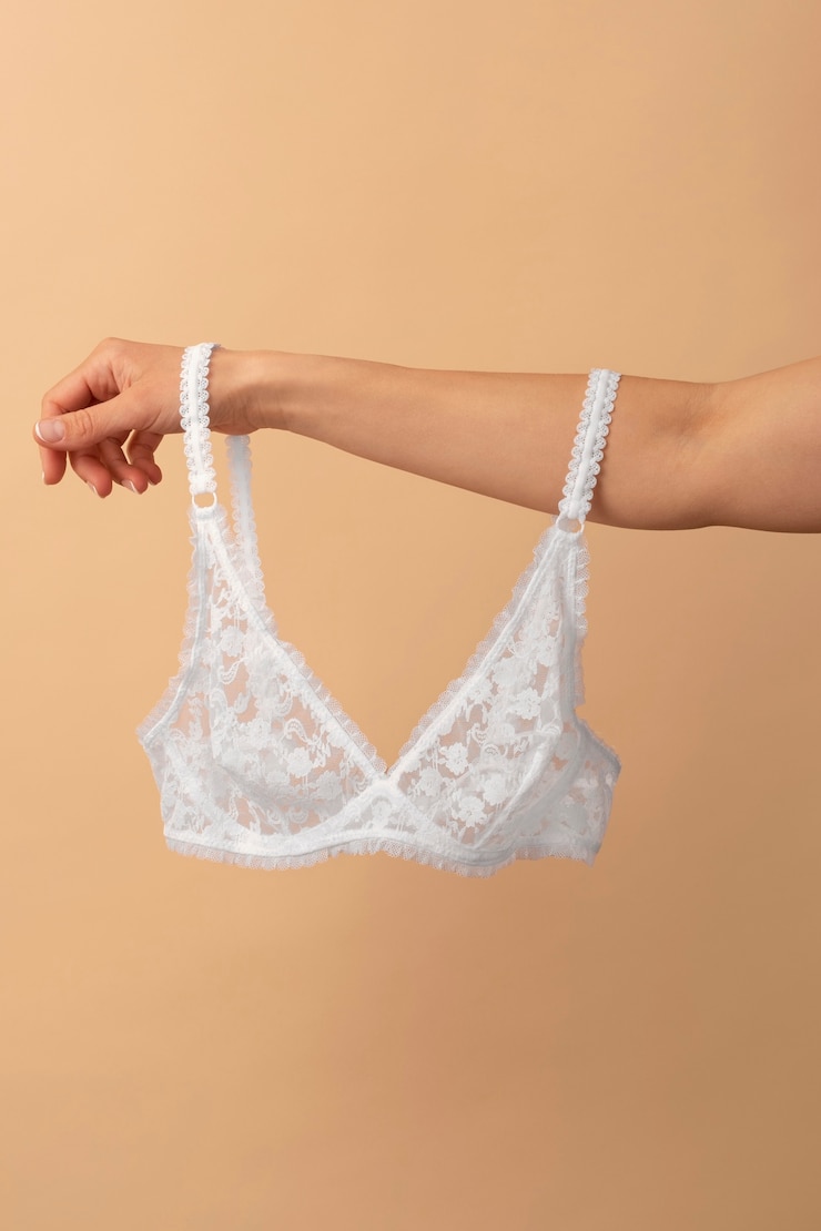 Foto grátis mão segurando a natureza morta de lingerie feminina