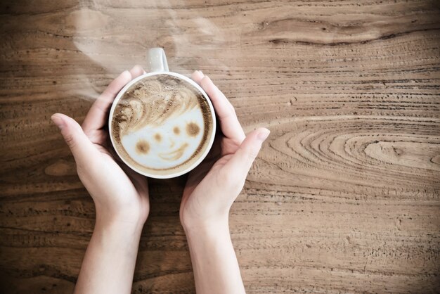 Mão segurando a xícara de café quente - pessoas com o conceito de café