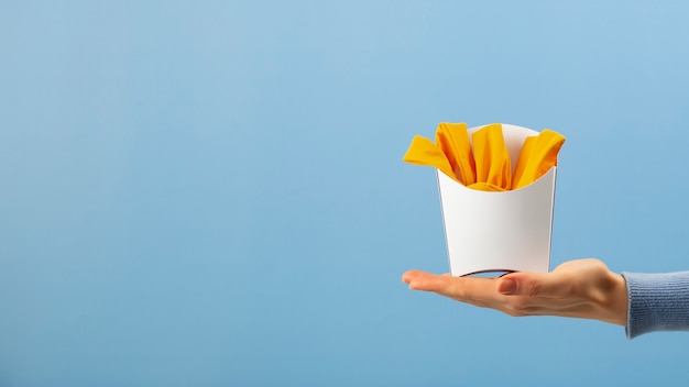 Foto grátis mão segurando batatas fritas feitas de roupas