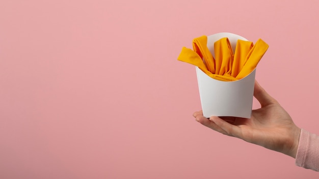 Foto grátis mão segurando batatas fritas feitas de roupas