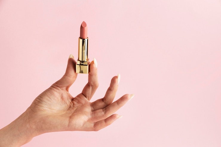 Foto grátis mão segurando batom rosa de perto
