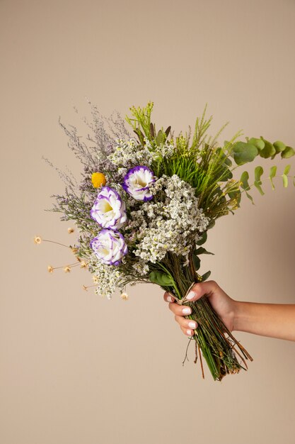 Mão segurando o arranjo de flores boho