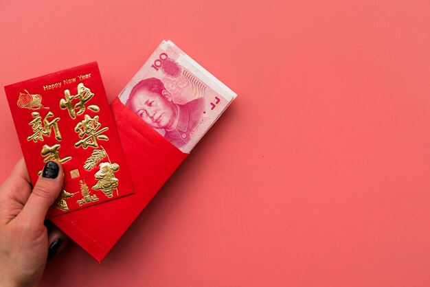 Mão segurando o cartão e as contas chinesas