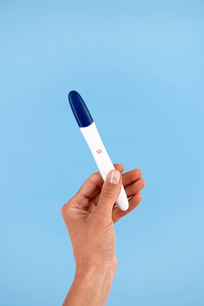 Mão segurando o teste de gravidez positivo