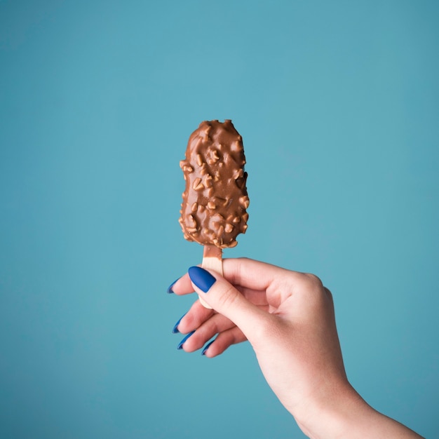 Mão segurando sorvete de chocolate