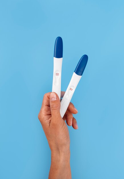 Mão segurando testes de gravidez positivos
