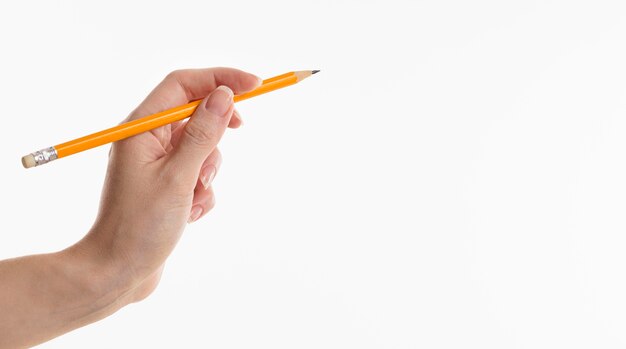 Mão segurando um lápis com espaço de cópia