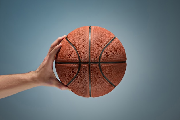 Foto grátis mão segurando uma bola de basquete