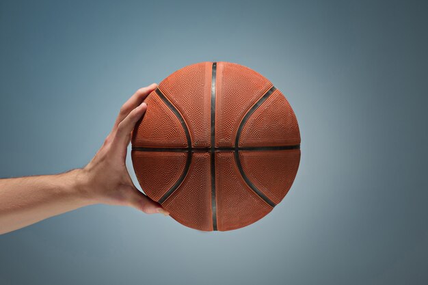 Mão segurando uma bola de basquete