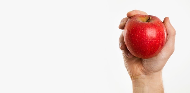 Mão segurando uma maçã com espaço de cópia
