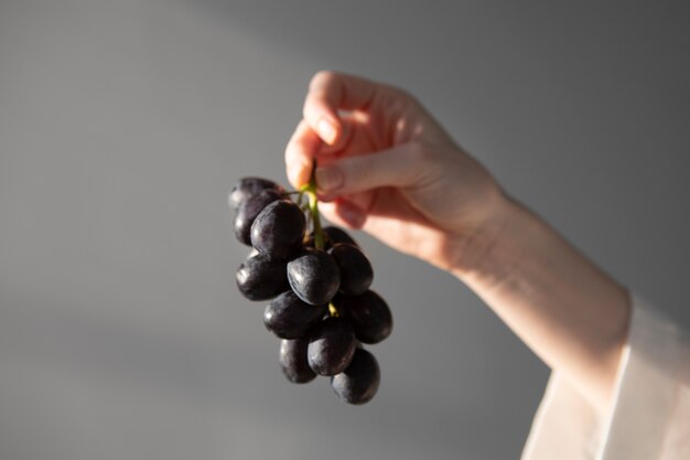 Mão segurando uvas de verão