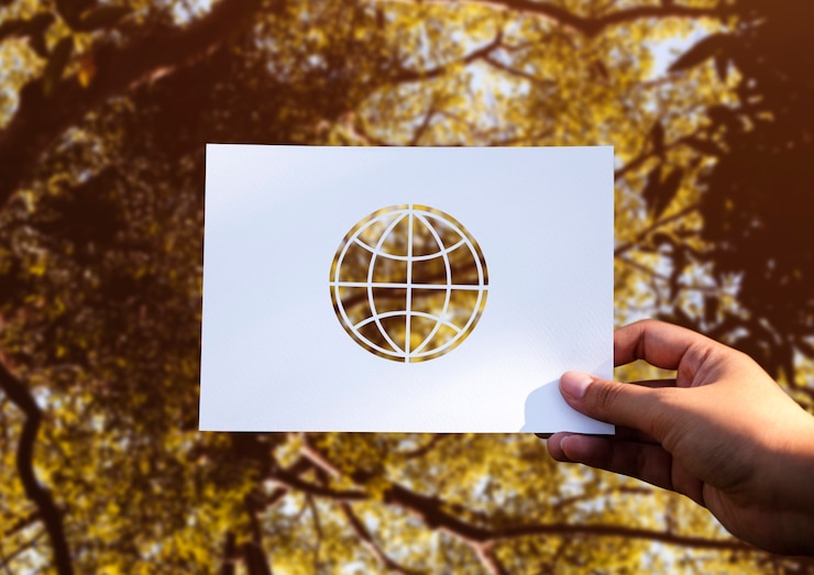 Foto grátis mão segure globo papel escultura com fundo de natureza