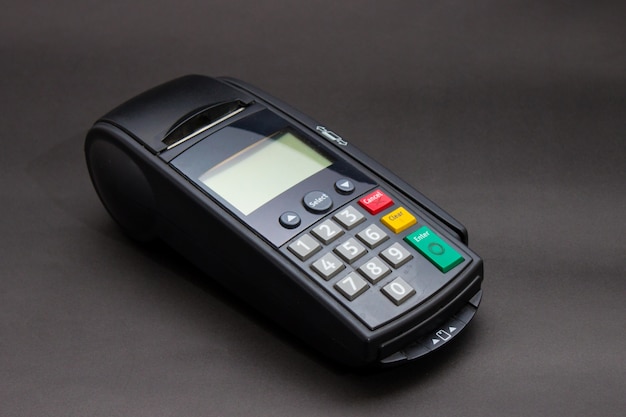 Mão Swiping Cartão De Crédito Na Loja. Mãos fêmeas com cartão de crédito e terminal de banco. Imagem em cores de um POS e cartões de crédito.