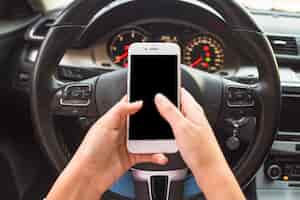 Foto grátis mão usando o celular na frente do volante no carro